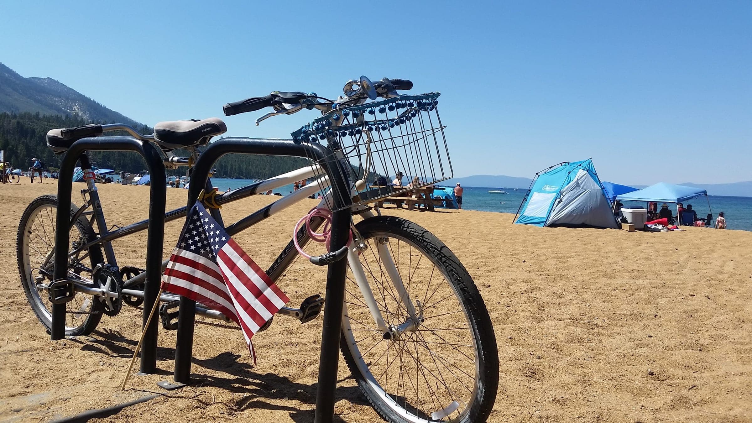 A red, white and blue tandem bicycle locked to an inverted-U bike rack