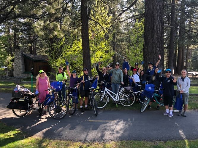 Volunteers with rakes and bags cleaning up a Tahoe bike path