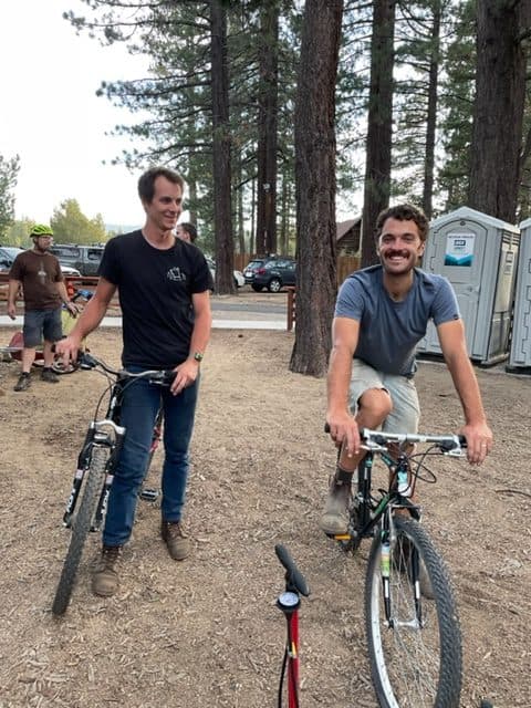 Two smiling volunteers with refurbished bikes at a Bike Kitchen event